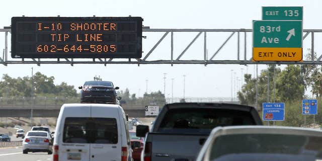 FILE - In this Sept. 11, 2015 file photo, a sign displays a shooter tip line above Interstate 10 in Phoenix.