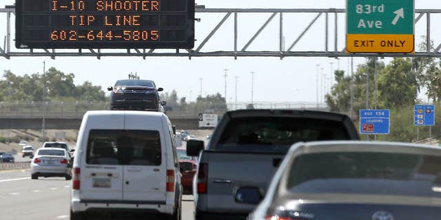 FILE - In this Sept. 11, 2015 file photo, a sign displays a shooter tip line above Interstate 10 in Phoenix.