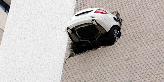April 28: No injuries were reported when the car seen here went through the 6th floor wall of a parking garage in Tulsa, Okla.