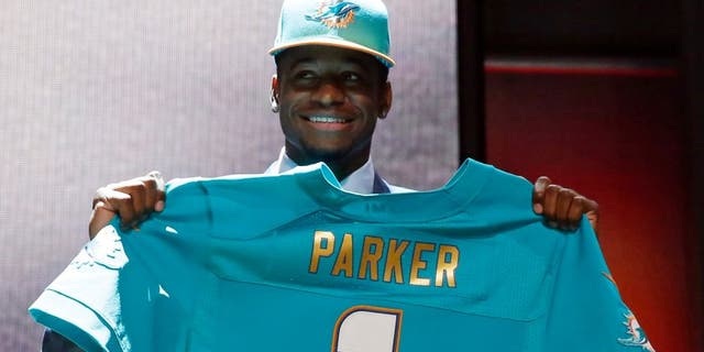 Louisville wide receiver Devante Parker poses for photos after being selected by the Miami Dolphins as the 14th pick in the first round of the 2015 NFL Draft, Thursday, April 30, 2015, in Chicago. (AP Photo/Charles Rex Arbogast)