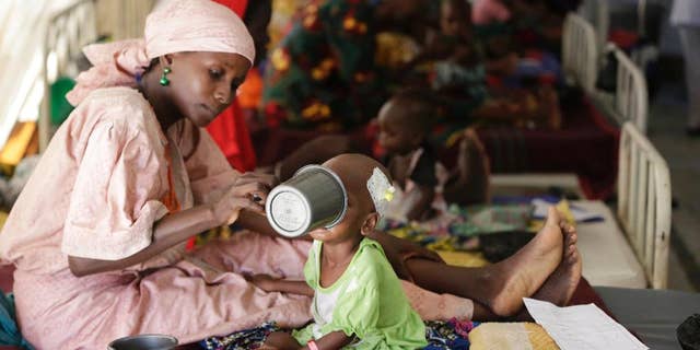 FILE - In this Monday Aug. 29, 2016 file photo, a mother feeds her malnourished child at a feeding centre run by Doctors Without Borders in Maiduguri Nigeria. During its seven-year uprising, Boko Haram extremists have killed more than 20,000 people and displaced more than 2.6 million in Nigeria and neighboring Cameroon, Niger and Chad. ( AP Photo/Sunday Alamba, File)