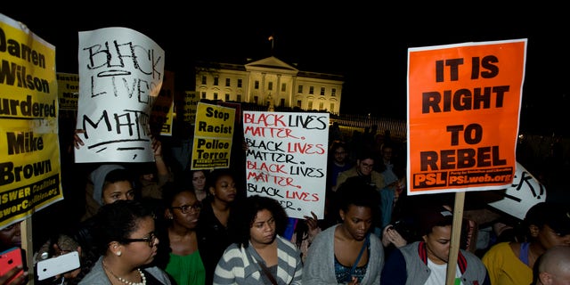 Protestors carry signs and gather in front of the White House in Washington, Tuesday, Nov. 25, 2014, after the Ferguson grand jury decided not to indict police officer Darren Wilson in the shooting death of Michael Brown. (AP Photo/Manuel Balce Ceneta)