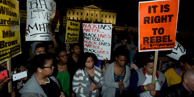 Protestors carry signs and gather in front of the White House in Washington, Tuesday, Nov. 25, 2014, after the Ferguson grand jury decided not to indict police officer Darren Wilson in the shooting death of Michael Brown. (AP Photo/Manuel Balce Ceneta)