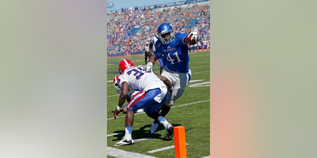 FILE - In this Sept. 21, 2013, file photo, Kansas tight end Jimmay Mundine (41) slips past Louisiana Tech defensive back Xavier Woods (39) for a touchdown during the second half of an NCAA college football game in Lawrence, Kan. Just about the only bright spot in the Kansas pass attack this season has been the guy who was perhaps the least expected to make a contribution: tight end Jimmay Mundine. He's also the only guy catching touchdown passes. (AP Photo/Orlin Wagner, File)