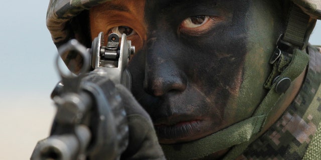 A South Korean Marine takes position during the joint military exercises between South Korea and the United States.