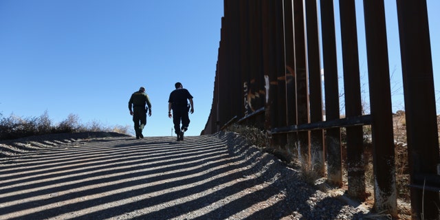 NOGALES, AZ - FEBRUARY 26: U.S. Customs and Border Protection personnel walk along a section of the recently-constructed fence at the U.S.-Mexico border on February 26, 2013 in Nogales, Arizona. The newest generation of fencing allows Border Patrol agents to see through the fence and is harder to scale from the Mexican side. (Photo by John Moore/Getty Images)