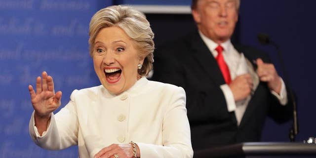 Democratic presidential nominee Hillary Clinton waves to the audience as Republican presidential nominee Donald Trump puts his notes away after the third presidential debate at UNLV in Las Vegas, Wednesday, Oct. 19, 2016. (AP Photo/John Locher)