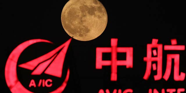 FILE - in This Tuesday, Nov. 15, 2016, file photo, the moon rises over a logo for AVIC or Aviation Industry Corp in Beijing, China. China is talking with the European Space Agency about collaborating on a human outpost on the moon. The chief engineer for China’s space agency disclosed the talks Wednesday in Chinese state media. (AP Photo/Ng Han Guan, File )