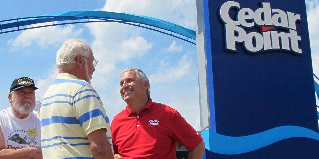 FILE - In this July 2, 2014, file photo, Matt Ouimet, chief executive of Cedar Fair Entertainment Co., greets a guest at Cedar Point amusement park, in Sandusky, Ohio.