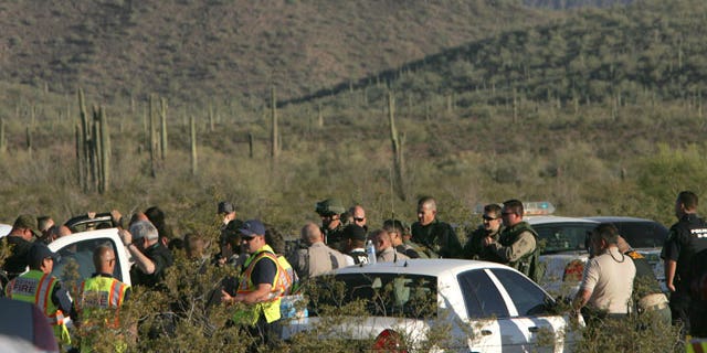 Law enforcement officers from different agencies gather to coordinate the search for a suspect that shot a Pinal County Sheriff's deputy Friday April 30, 2010 in the desert southwest of Stanfield, Ariz. Pinal County sheriff's Lt. Tamatha Villar says the deputy suffered a superficial wound to his abdomen after being shot with an AK-47 assault rifle.