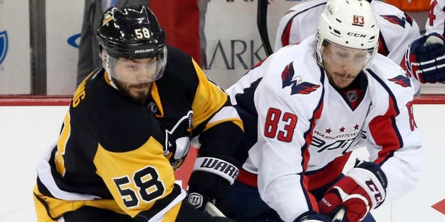 May 2, 2016; Pittsburgh, PA, USA; Pittsburgh Penguins defenseman Kris Letang (58) and Washington Capitals center Jay Beagle (83) chase the puck during the second period in game three of the second round of the 2016 Stanley Cup Playoffs at the CONSOL Energy Center. The Pens won 3-2. Mandatory Credit: Charles LeClaire-USA TODAY Sports