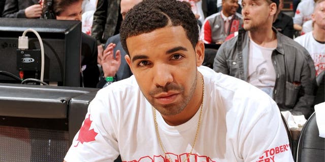 TORONTO, CANADA - April 19: Drake sits on the sideline during Game One of the Eastern Conference Quarterfinals of the 2014 NBA playoffs with the Brooklyn Nets against the Toronto Raptors on April 19, 2014 at the Air Canada Centre in Toronto, Ontario, Canada. NOTE TO USER: User expressly acknowledges and agrees that, by downloading and or using this Photograph, user is consenting to the terms and conditions of the Getty Images License Agreement. Mandatory Copyright Notice: Copyright 2014 NBAE (Photo by Ron Turenne/NBAE via Getty Images)â¨