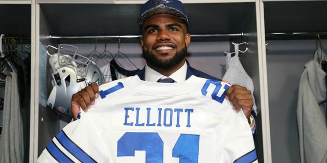 Apr 29, 2016; Irving, TX, USA; Dallas Cowboys number one draft pick Ezekiel Elliott holds his jersey in the locker room at Dallas Cowboys Headquarters Mandatory Credit: Matthew Emmons-USA TODAY Sports