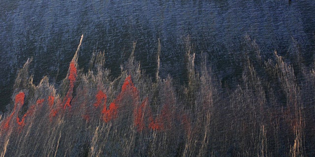 May 5: Oil and sheen are seen moving past a rig, top right, in the waters of Chandeleur Sound, La.