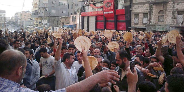 May 3: In this citizen journalism image made on a mobile phone and acquired by the AP, Syrian men carry bread loaves during a protest against Syrian President Bashar Assad's regime in the coastal town of Banias, Syria.