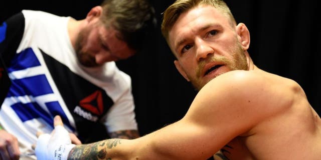 LAS VEGAS, NEVADA - DECEMBER 12: (R-L) Conor McGregor of Ireland gets his hands wrapped by coach John Kavanaugh backstage during the UFC 194 event inside MGM Grand Garden Arena on December 12, 2015 in Las Vegas, Nevada. (Photo by Jeff Bottari/Zuffa LLC/Zuffa LLC via Getty Images)