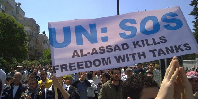 May 6: In this citizen journalism image made on a mobile phone and acquired by the AP, Syrian anti-government protesters carry a banner during a rally in the central city of Homs, Syria.