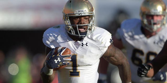 Nov 29, 2014; Los Angeles, CA, USA; Notre Dame Fighting Irish running back Greg Bryant (1) carries the ball against the Southern California Trojans at Los Angeles Memorial Coliseum. USC defeated Notre Dame 49-14. Mandatory Credit: Kirby Lee-USA TODAY Sports