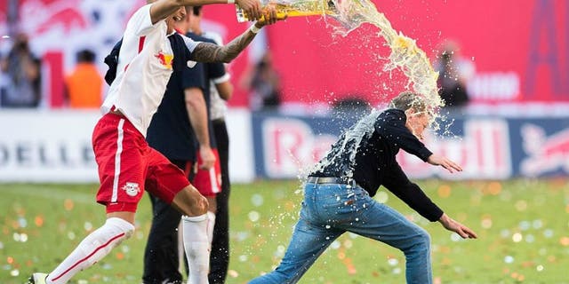 Leipzigï¿½ï¿½s Davie Selke (L) pours beer over headcoach Ralf Rangnick after the German second division Bundesliga football match between RB Leipzig and Karlsruher SC at the Red Bull Arena in Leipzig, eastern Germany, on May 8, 2016. Leipzig won the match 2-0 and will be promoted to the first division Bundesliga next season. / AFP / Robert MICHAEL (Photo credit should read ROBERT MICHAEL/AFP/Getty Images)