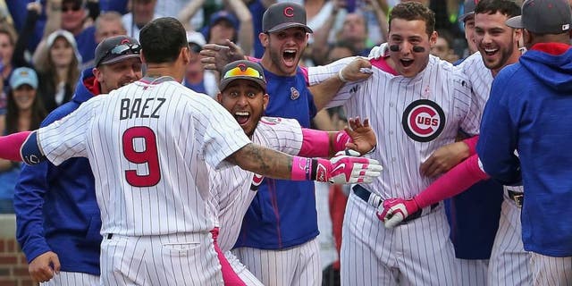 CHICAGO, IL - MAY 08: Javier Baez #9 of the Chicago Cubs is greeted by teammates after hitting the game-winning, walk off home run against the Washington Nationals at Wrigley Field on May 8, 2016 in Chicago, Illinois. The Cubs defeated the Nationals 4-3 in 13 innings. (Photo by Jonathan Daniel/Getty Images)