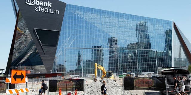 The Minneapolis skyline is reflected in the new U.S. Bank Stadium in Minneapolis as it nears completion for the $1.2 billion home of the Minnesota Vikings NFL football team beginning this season in Minneapolis. (AP Photo/Jim Mone)