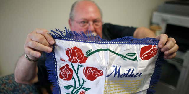 May 5, 2015: Don Lamoureux displays a World War II era pillow sham at a senior center in Millville, Mass., which his son purchased from an online auction site.