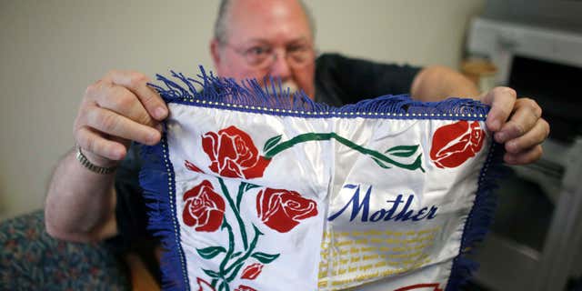 May 5, 2015: Don Lamoureux displays a World War II era pillow sham at a senior center in Millville, Mass., which his son purchased from an online auction site.