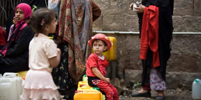 May 9, 2015: A girl waits for her turn to fill buckets with water from a public tap amid an acute shortage of water, in Sanaa, Yemen.