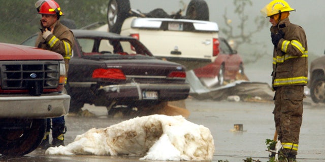 May 10: Overturned cars and debris litter the street after a violent storm tore through Norman, Okla.