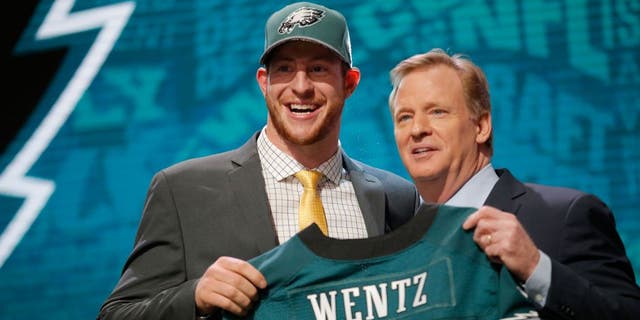 CHICAGO, IL - APRIL 28: (L-R) Carson Wentz of the North Dakota State Bison holds up a jersey with NFL Commissioner Roger Goodell after being picked #2 overall by the Philadelphia Eagles during the first round of the 2016 NFL Draft at the Auditorium Theatre of Roosevelt University on April 28, 2016 in Chicago, Illinois. (Photo by Jon Durr/Getty Images)