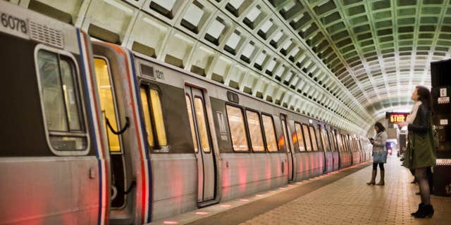 In this photo taken March 12, 2015, passengers wait on the platform before boarding a train at the U Street Metro Station in Washington.