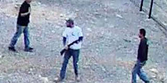In this still image taken from security video on Saturday, April 30, 2016 and released by the National Park Service, three men inside the perimeter fence at the edge of Devils Hole in Death Valley National Park, Nev.