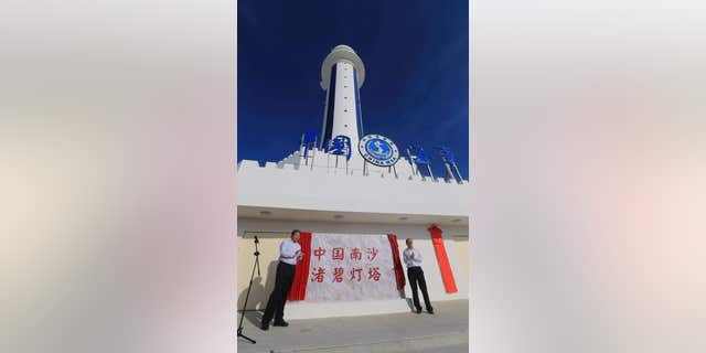 FILE - In this April 5, 2016 file photo provided by China's Xinhua News Agency, guests attend the completion ceremony for the construction of a lighthouse on Zhubi Reef of Nansha Islands, known as the Spratly Islands, in the South China Sea.