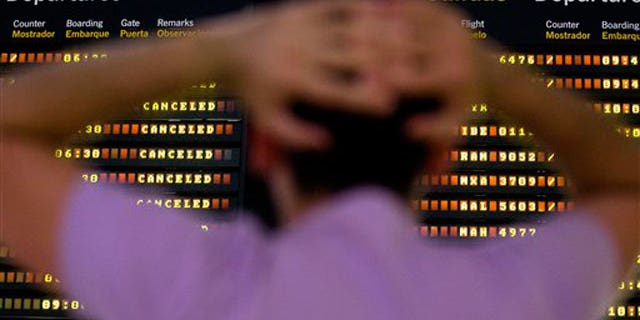 May 11: A passenger looks at a flight departure screen showing all flights canceled at the international airport in Seville, Spain.