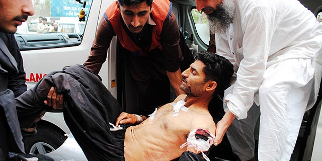 May 13: In this photo released by China's Xinhua News Agency, people transfer an injured man to a hospital in Peshawar, Pakistan.