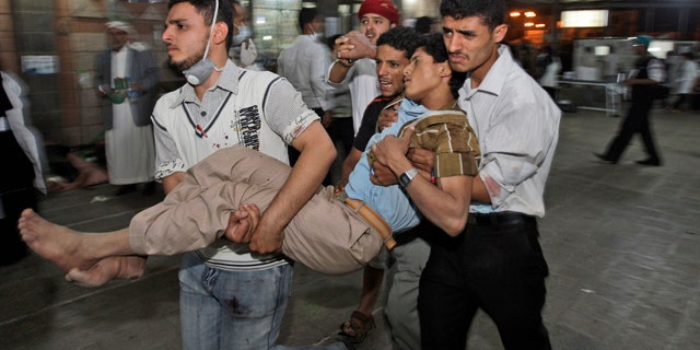 May 11: Anti-government protestors carry a wounded demonstrator to a field hospital during clashes with Yemeni security forces in Sanaa, Yemen.