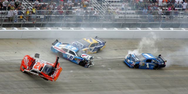 DOVER, DE - SEPTEMBER 27: (L-R) Joey Logano, driver of the #20 Home Depot Toyota, flips his car after he was involved in a wreck with Reed Sorenson, driver of the #43 Valvoline Dodge, Robby Gordon, driver of the #7 Camping World Toyota and Martin Truex Jr., driver of the #1 Vaseline MEN Body Lotion Chevrolet during the NASCAR Sprint Cup Series AAA 400 at Dover International Speedway on September 27, 2009 in Dover, Delaware. (Photo by Jerry Markland/Getty Images for NASCAR)