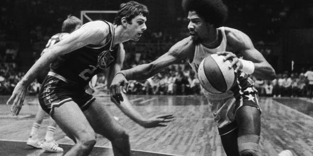 6th May 1976: American basketball player Julius Erving of the New Jersey Nets, nicknamed 'Dr J,' driving past Bobby Jones of the Denver Nuggets during a game. (Photo by Larry C. Morris/New York Times Co./Getty Images)