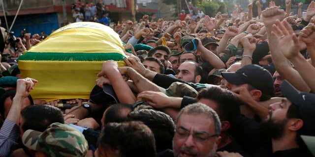 May 13, 2016: Hezbollah supporters carry the coffin of their slain commander Mustafa Badreddine, draped in a Hezbollah flag, during his funeral procession in a southern suburb of Beirut, Lebanon.
