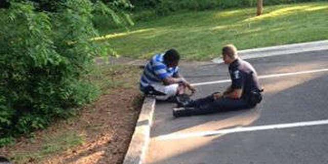 Photo shows Officer Tim Purdy talking with autistic high school student.
