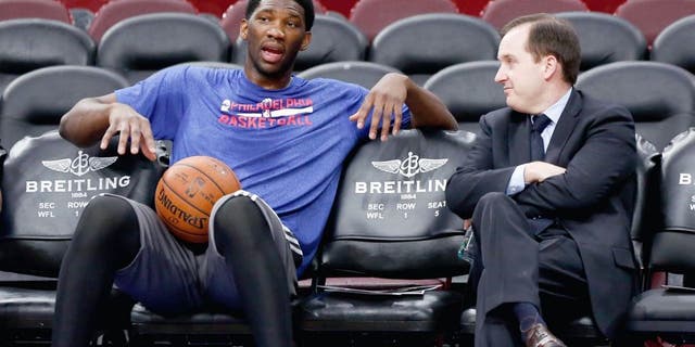 Dec 15, 2014; Philadelphia, PA, USA; Injured Philadelphia 76ers center Joel Embiid (left) talks with general manager and president Sam Hinkie (right) before a game against the Boston Celtics at Wells Fargo Center. Mandatory Credit: Bill Streicher-USA TODAY Sports