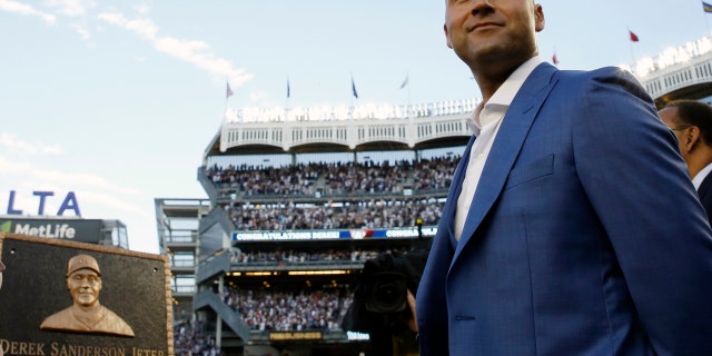 Retired New York Yankees shortstop Derek Jeter, right, looks around during a pregame ceremony after his No. 2 was retired in Monument Park at Yankee Stadium in New York, Sunday, May 14, 2017.