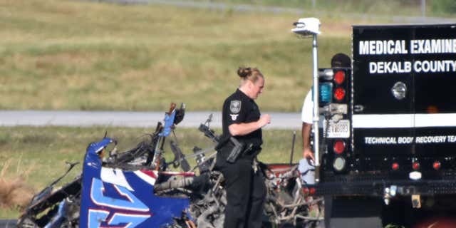 Authorities investigate the site of a small plane crash at DeKalb Peachtree Airport on Saturday, May 14, 2016, near the end of the Good Neighbor Day Air Show.