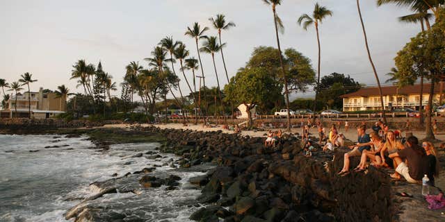Feb. 9, 2016: Tourists and locals watch the sunset from White Sands Beach Park in Kailua-Kona, Hawaii.