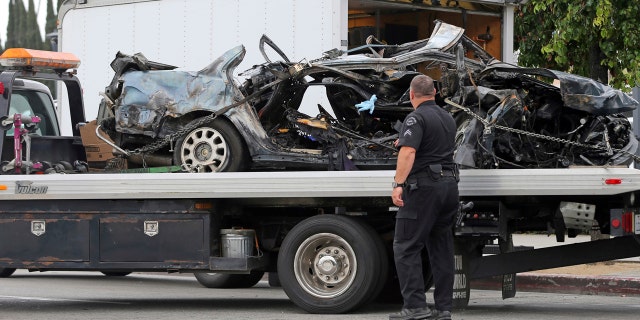 A Los Angeles police investigator stands at the scene of a fiery crash that killed two stolen-car suspects early Sunday, May 14, 2017, in Los Angeles.
