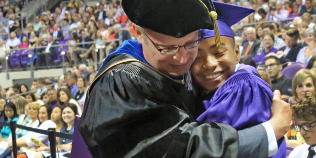 Fourteen year old Carson Huey-You gets a hug from his mentor, physics professor Magnus Rittby, after receiving a bachelor's degree in physics at the Texas Christian University commencement held in Fort Worth on Saturday, May 13, 2017.