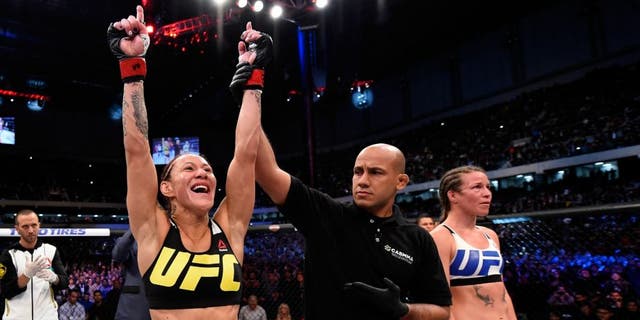CURITIBA, BRAZIL - MAY 14: (L-R) Cristiane 'Cyborg' Justino of Brazil celebrates after defeating Leslie Smith in their women's catchweight bout during the UFC 198 event at Arena da Baixada stadium on May 14, 2016 in Curitiba, Parana, Brazil. (Photo by Josh Hedges/Zuffa LLC/Zuffa LLC via Getty Images)
