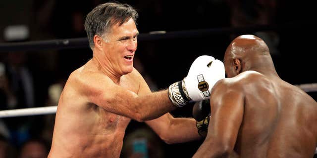May 15, 2015: Former Republican presidential candidate Mitt Romney, left, lands a punch against five-time heavyweight boxing champion Evander Holyfield at a charity fight night event.