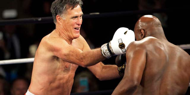 May 15, 2015: Former Republican presidential candidate Mitt Romney, left, lands a punch against five-time heavyweight boxing champion Evander Holyfield at a charity fight night event.