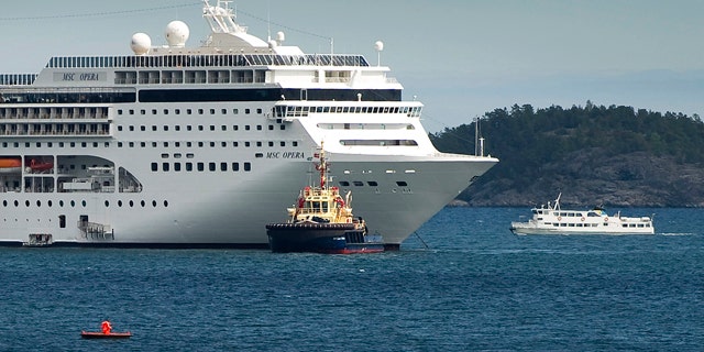 May 16: The cruise ship MSC Opera, left, carrying about 1,800 passengers, is towed into the Swedish port of Nynaeshamn.